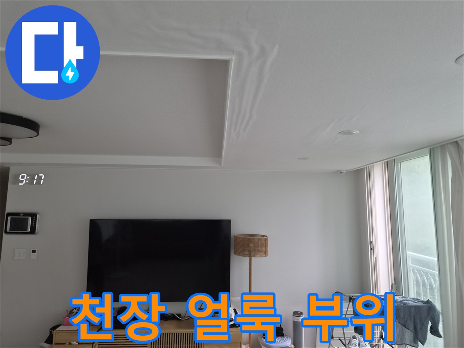 거실 천장에 나타난 누수 흔적과 변색된 벽지