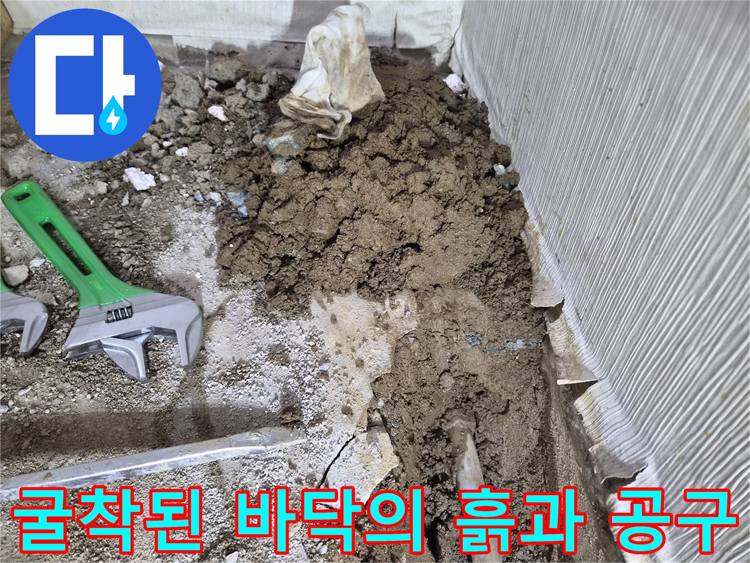 누수 지점 확인을 위해-파헤쳐진 흙더미와-몽키스패너가 놓인 현장