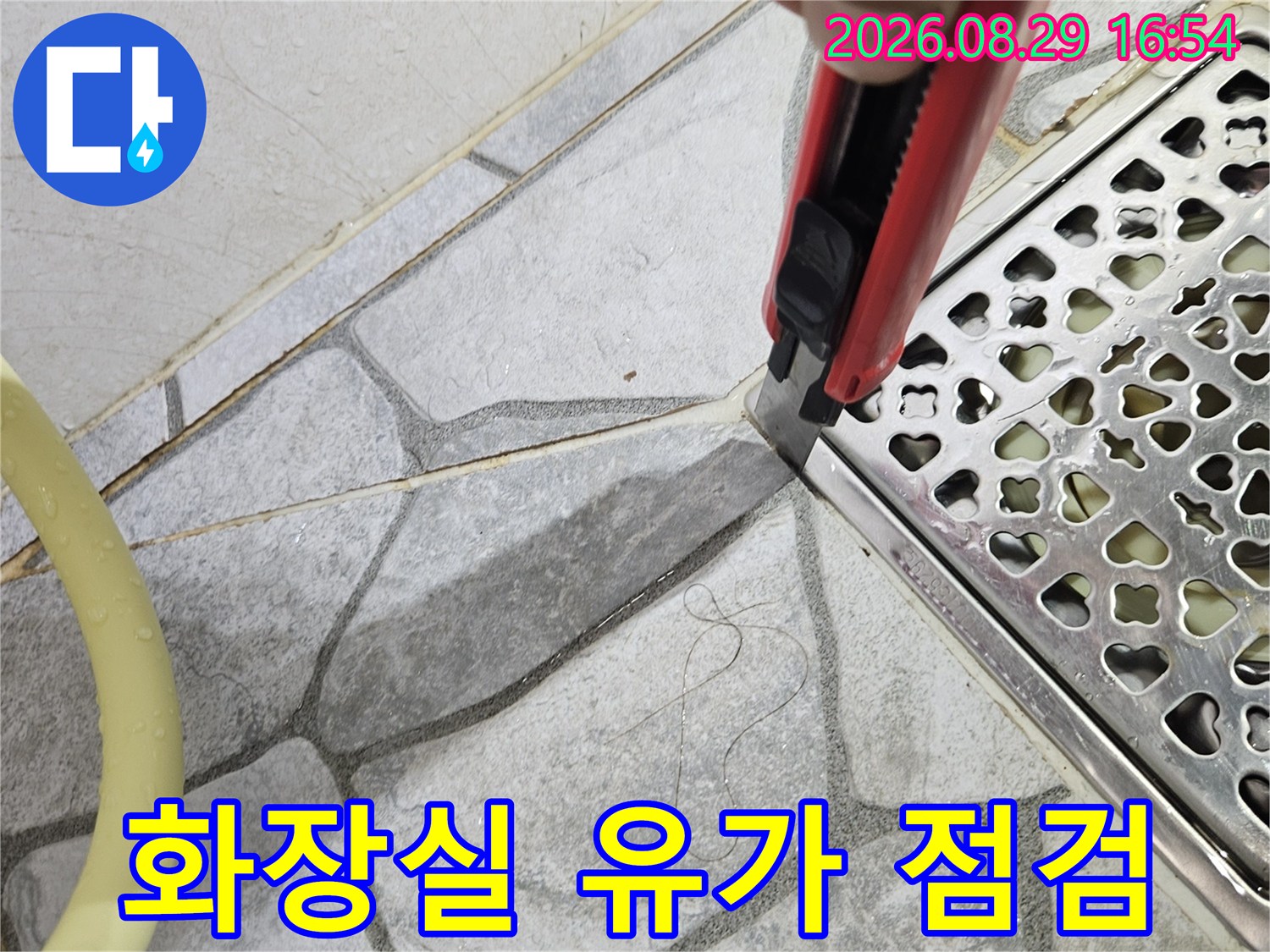 스테인리스 재질의 하트 문양 배수구와 타일 경계선 상세 사진