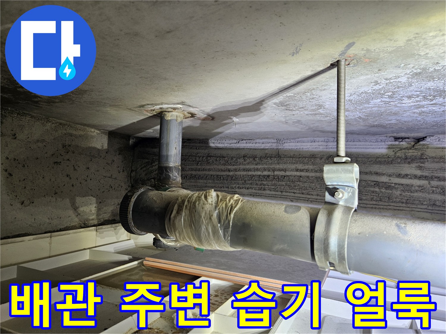 아래층 천장 슬라브 배관 주변의 습기와 오염 상태를 보여주는 사진입니다.