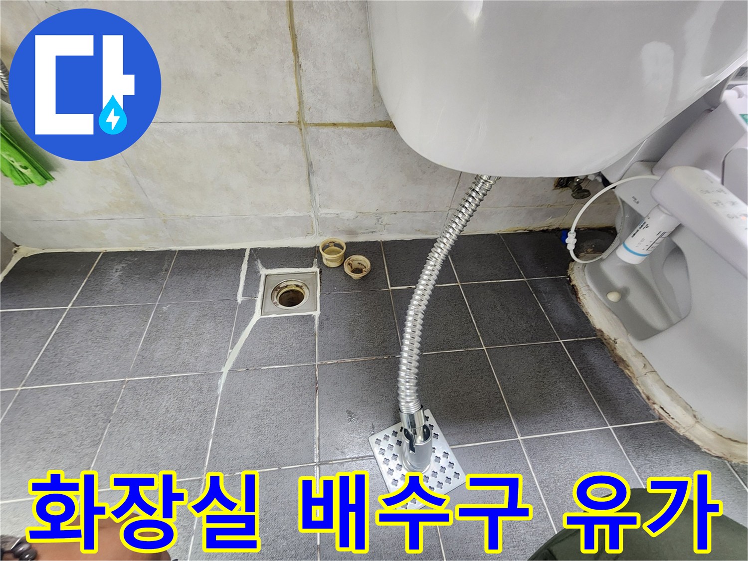 타일 바닥에 설치된 하수구 유가와 세면대 배관 연결부