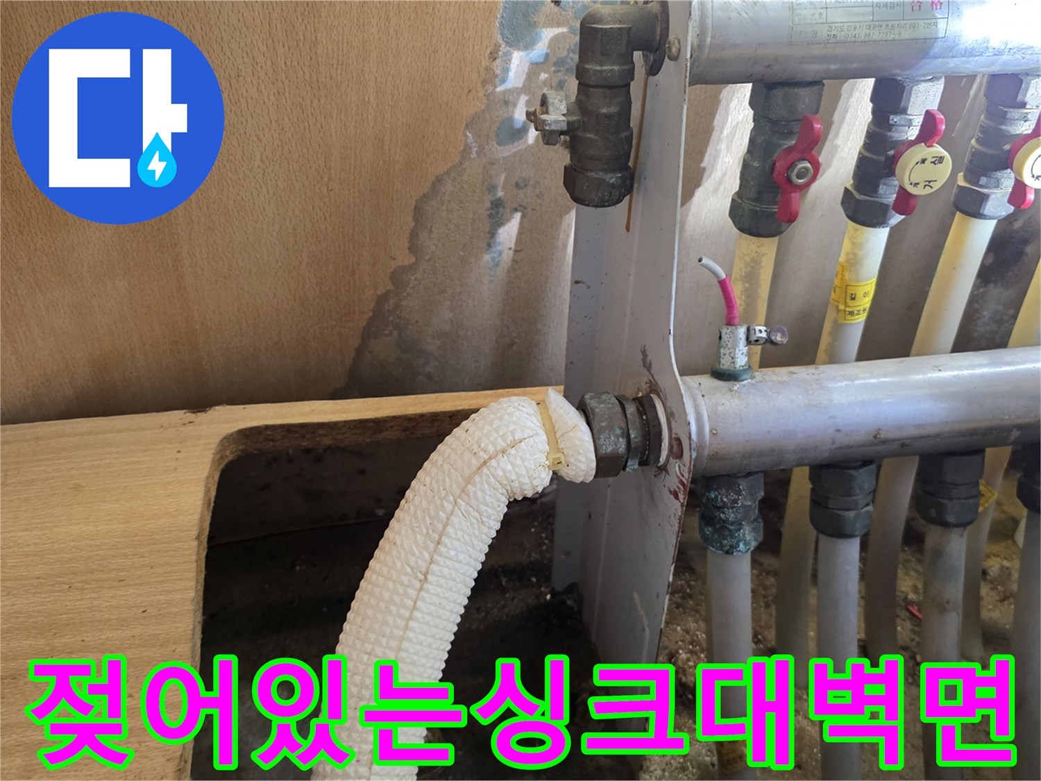 습기가 올라온 싱크대 하부 벽면과 분배기 배관 모습