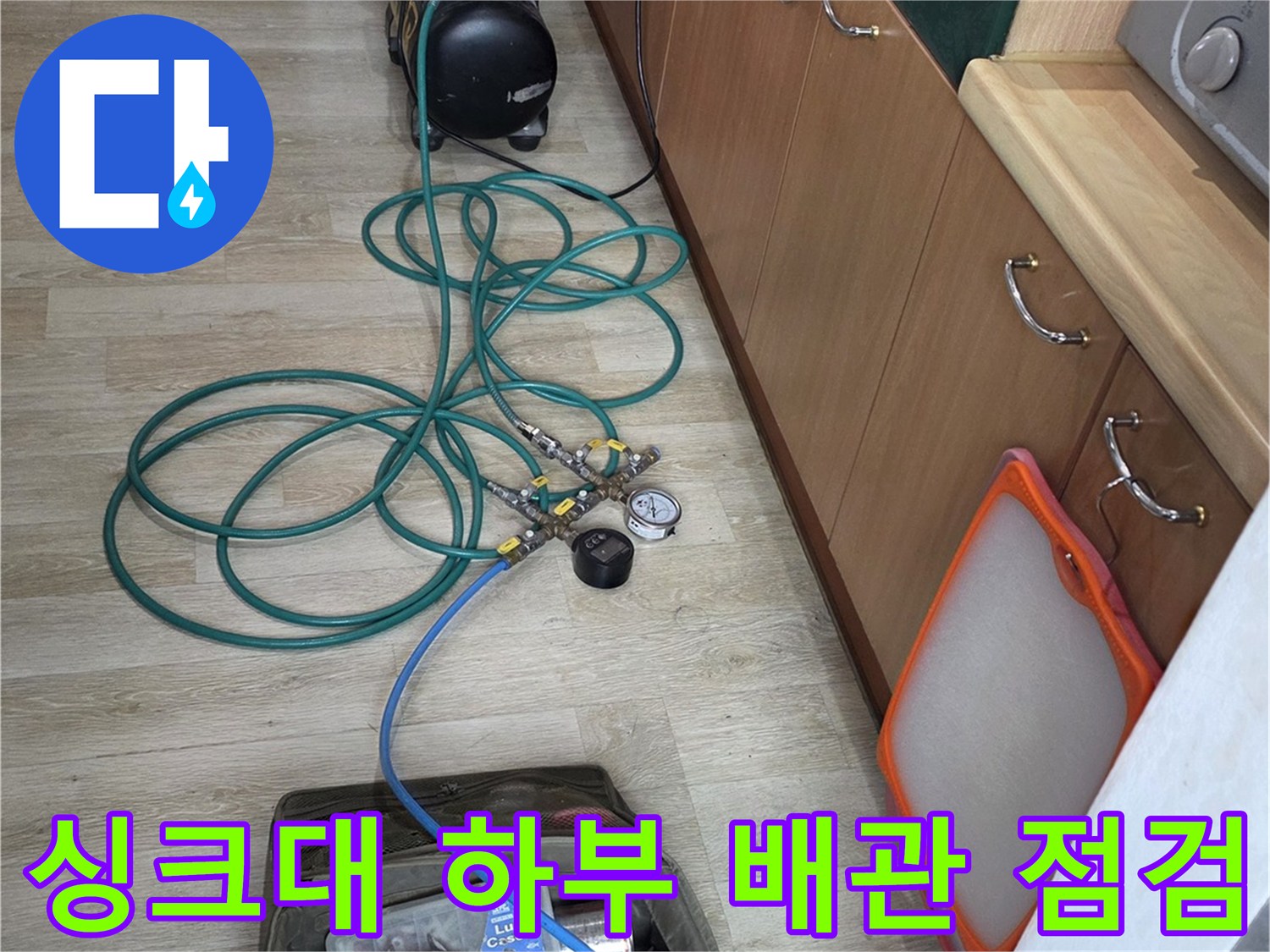 싱크대 아래쪽 공간에 설치된 누수 탐지용 압력 게이지와 연결 호스