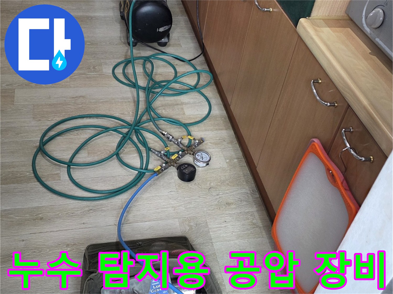 싱크대 하단 배관에 연결된 압력계와 파란색 호스