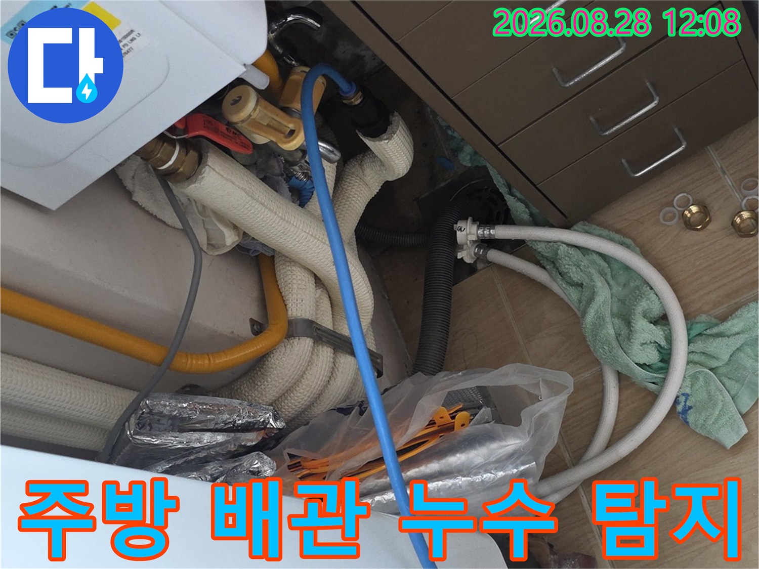 싱크대 하부장 내부에 노출된 보일러 분배기와 급수 배관의 정밀 진단 장면입니다.