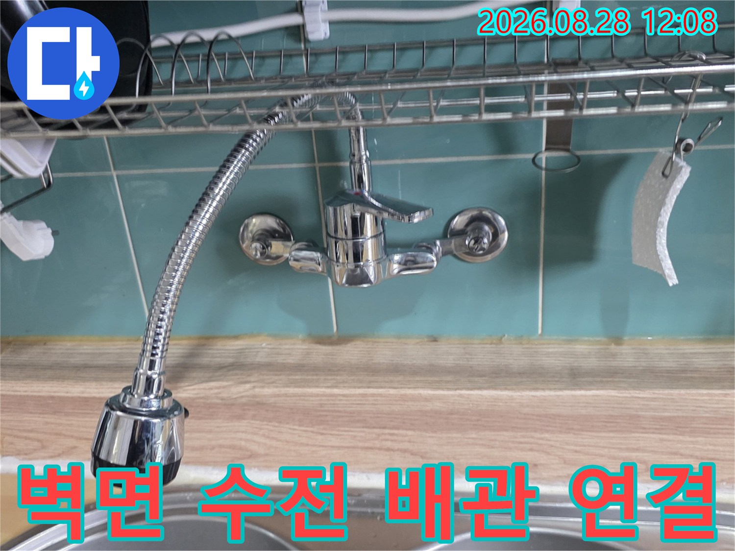 타일 벽면에 설치된 싱크대용 수전과 샤워 호스 상세 모습