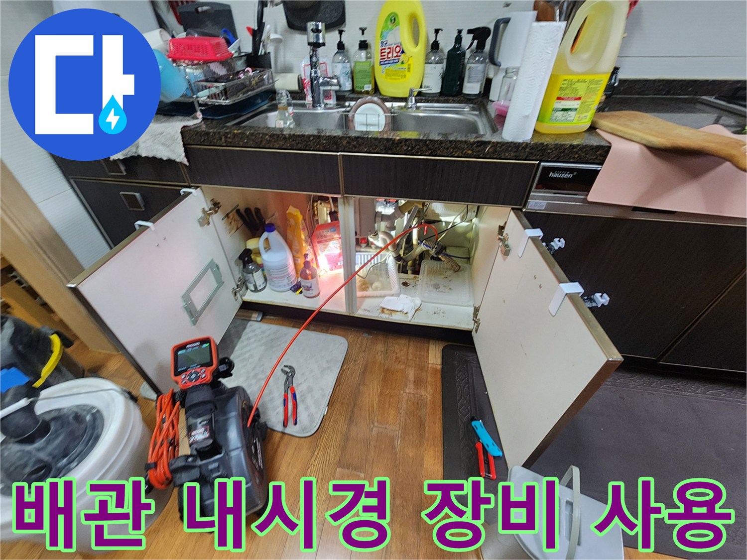 내시경 카메라와 점검 도구가 배치된 싱크대 밑 공간