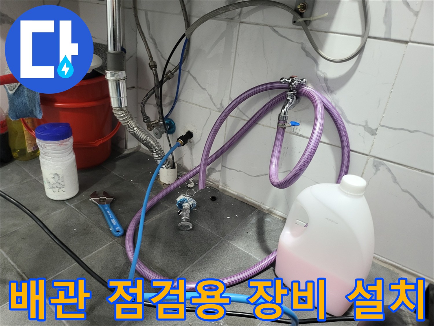 바닥 배관 연결 부위에 압력 측정 호스를 연결한 현장 사진