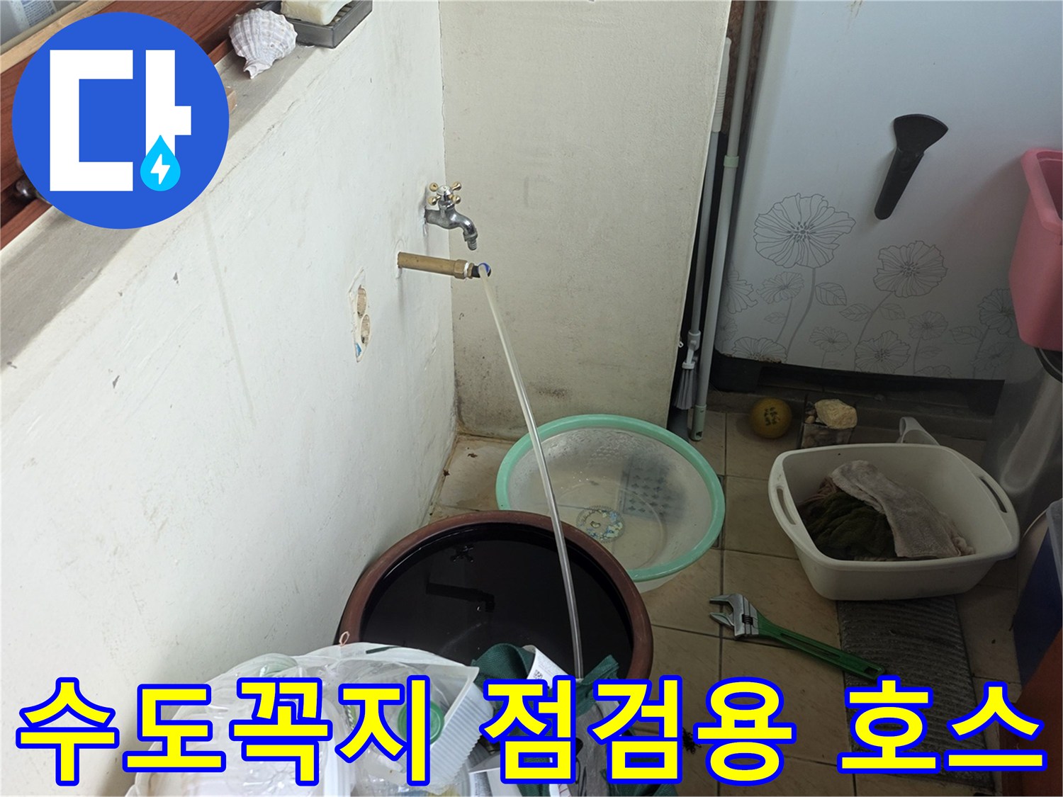 벽면 수도꼭지에 연결된 가느다란 점검 관