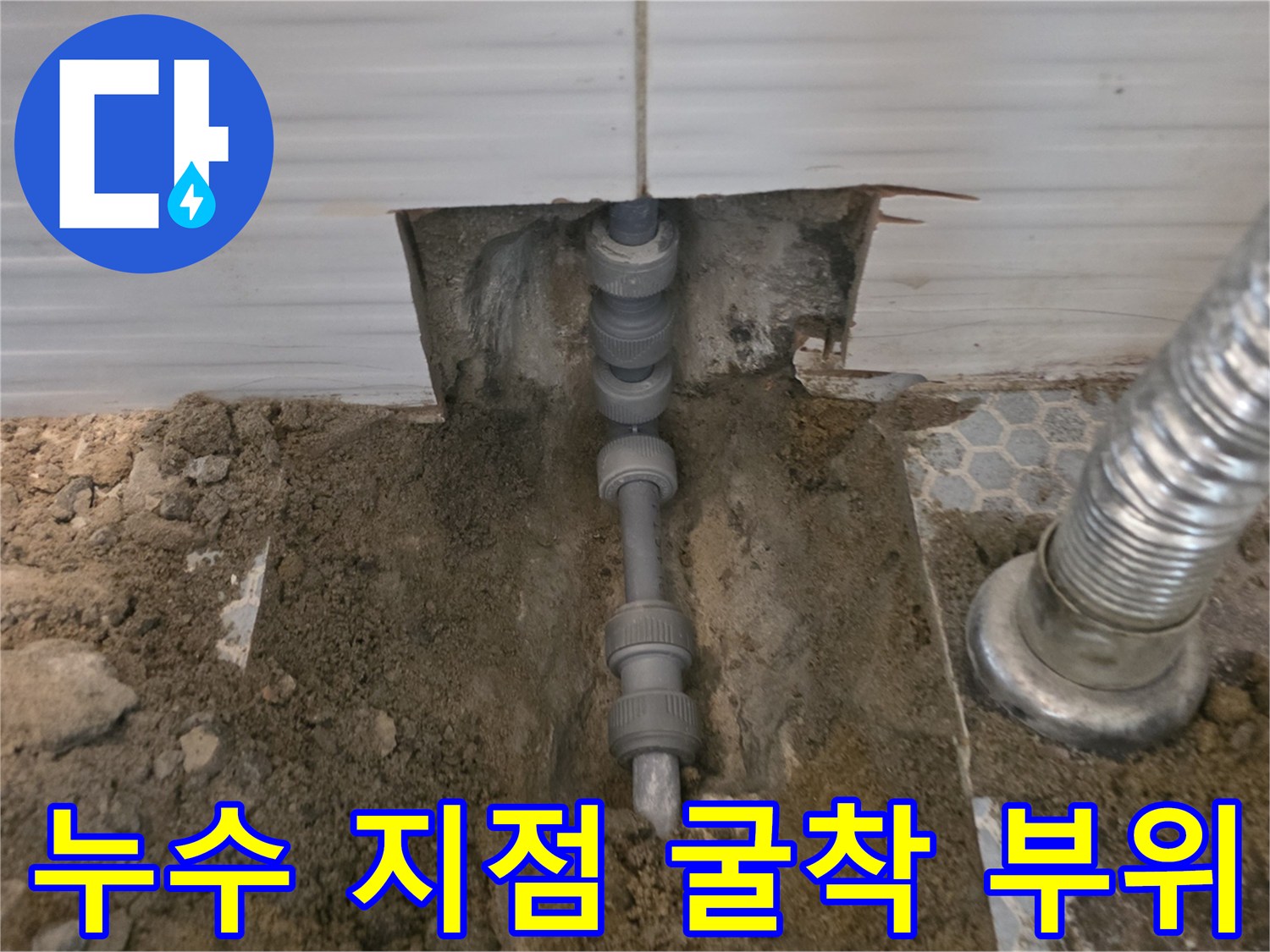 바닥 타일 제거 후-드러난 배관 연결부와 주변 토사