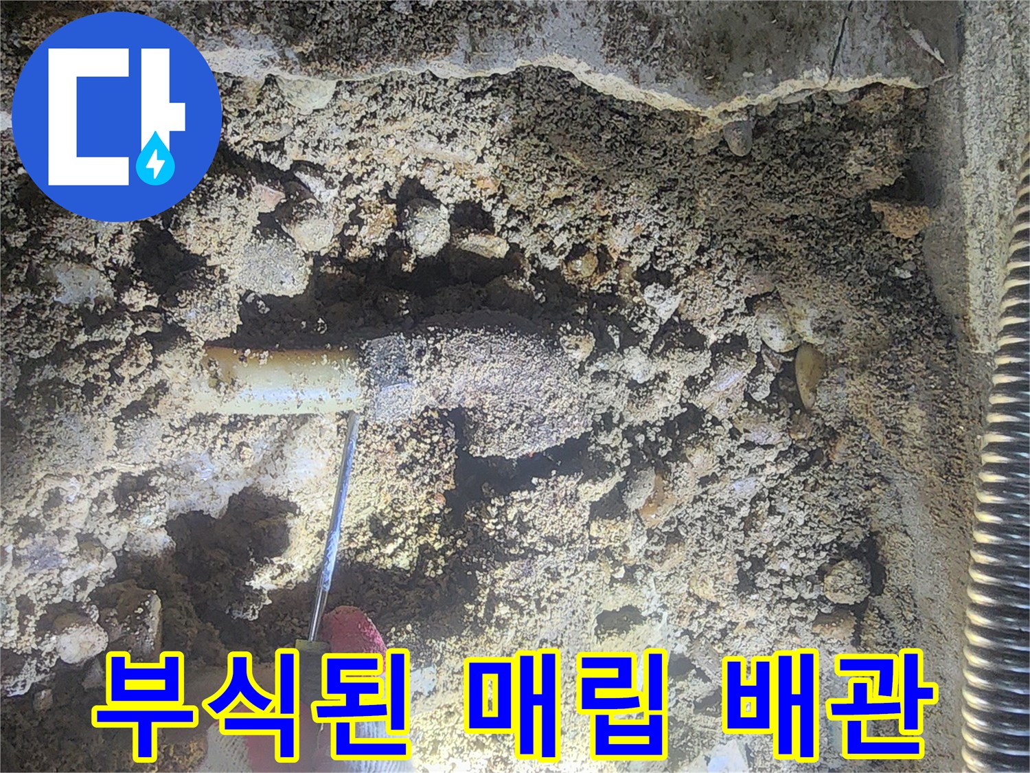 싱크대 아래 굴착 부위에서 발견된 - 심하게 부식되어 구멍이 난 금속제 분배기 모습
