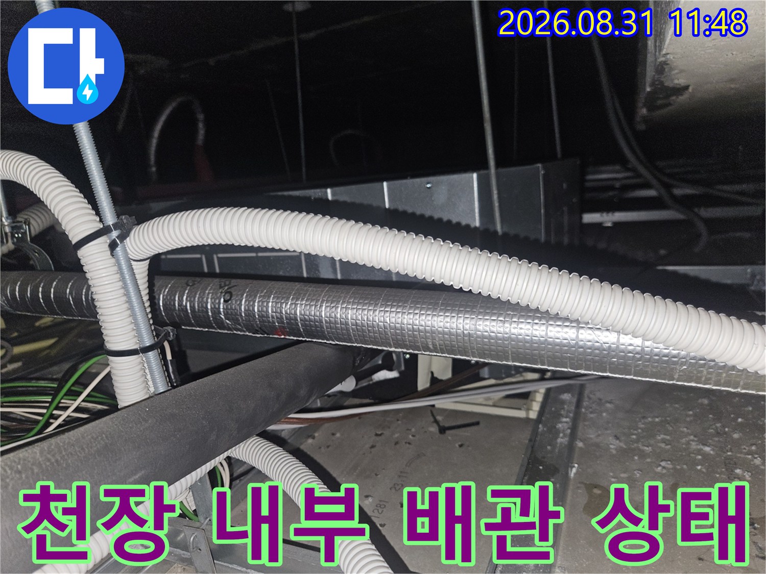 복잡하게 연결된 에어컨 드레인 호스와 은박 보온재 마감 배관의 근접 촬영