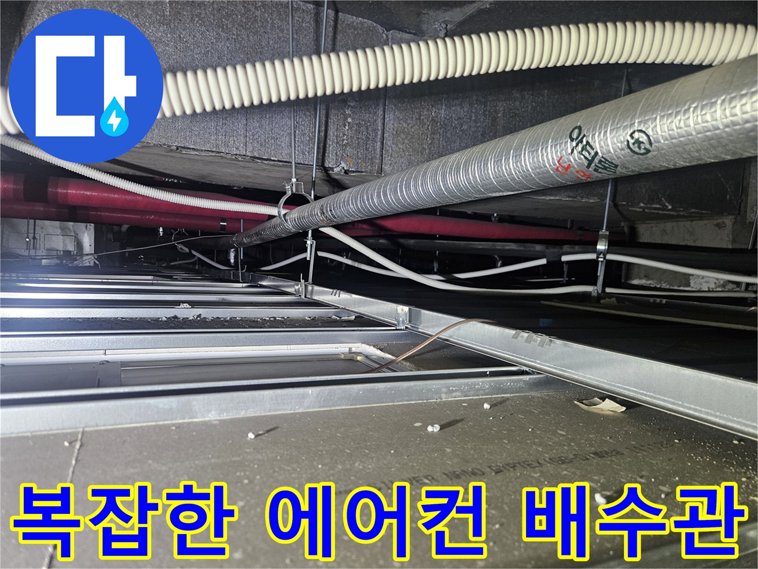 천장 내부를 가로지르는-흰색 주름관과 은박 보온재가 입혀진 관로