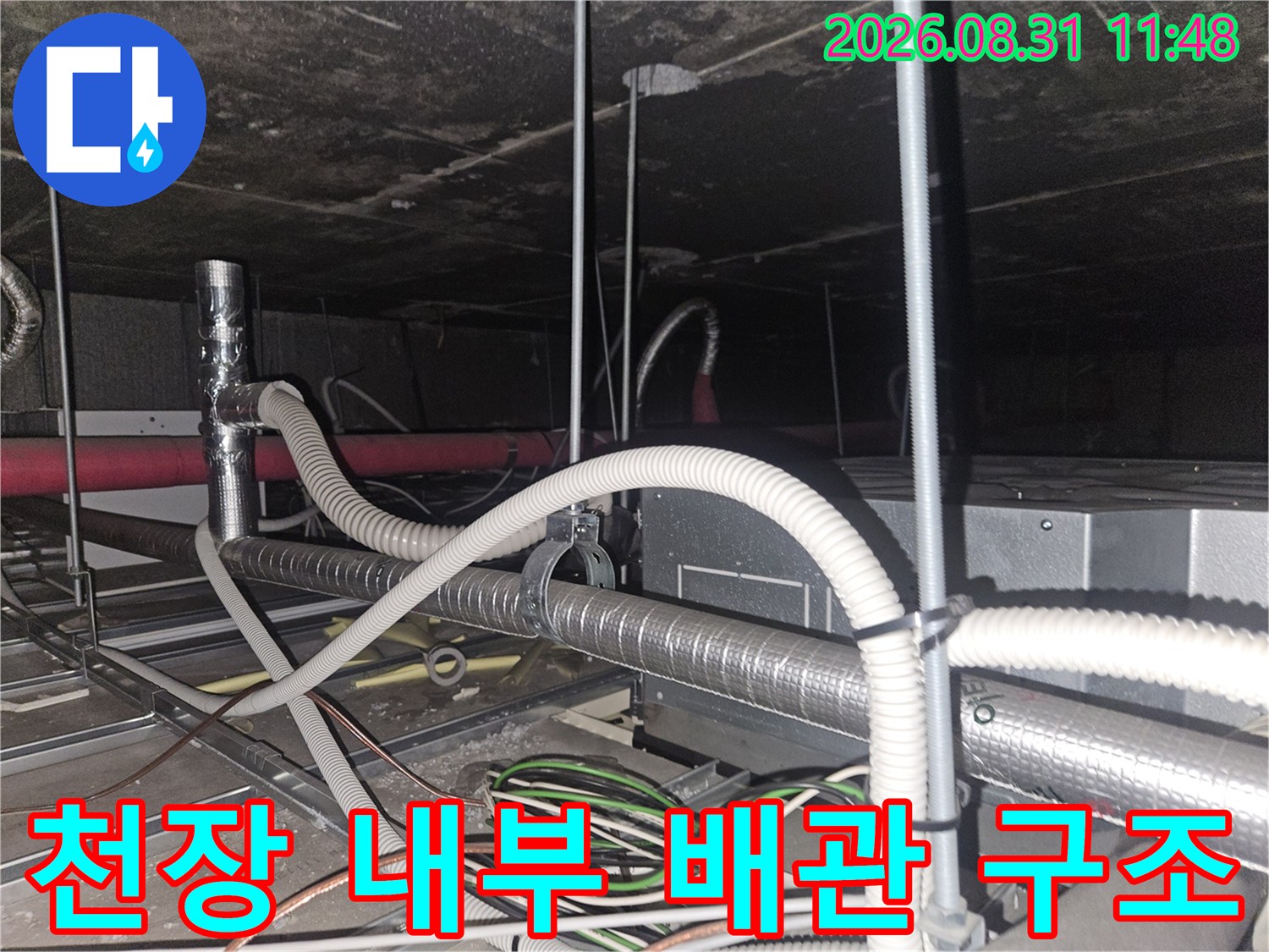 천장 텍스 사이로 보이는 에어컨 드레인 호스와 은색 보온재 배관 작업 상황