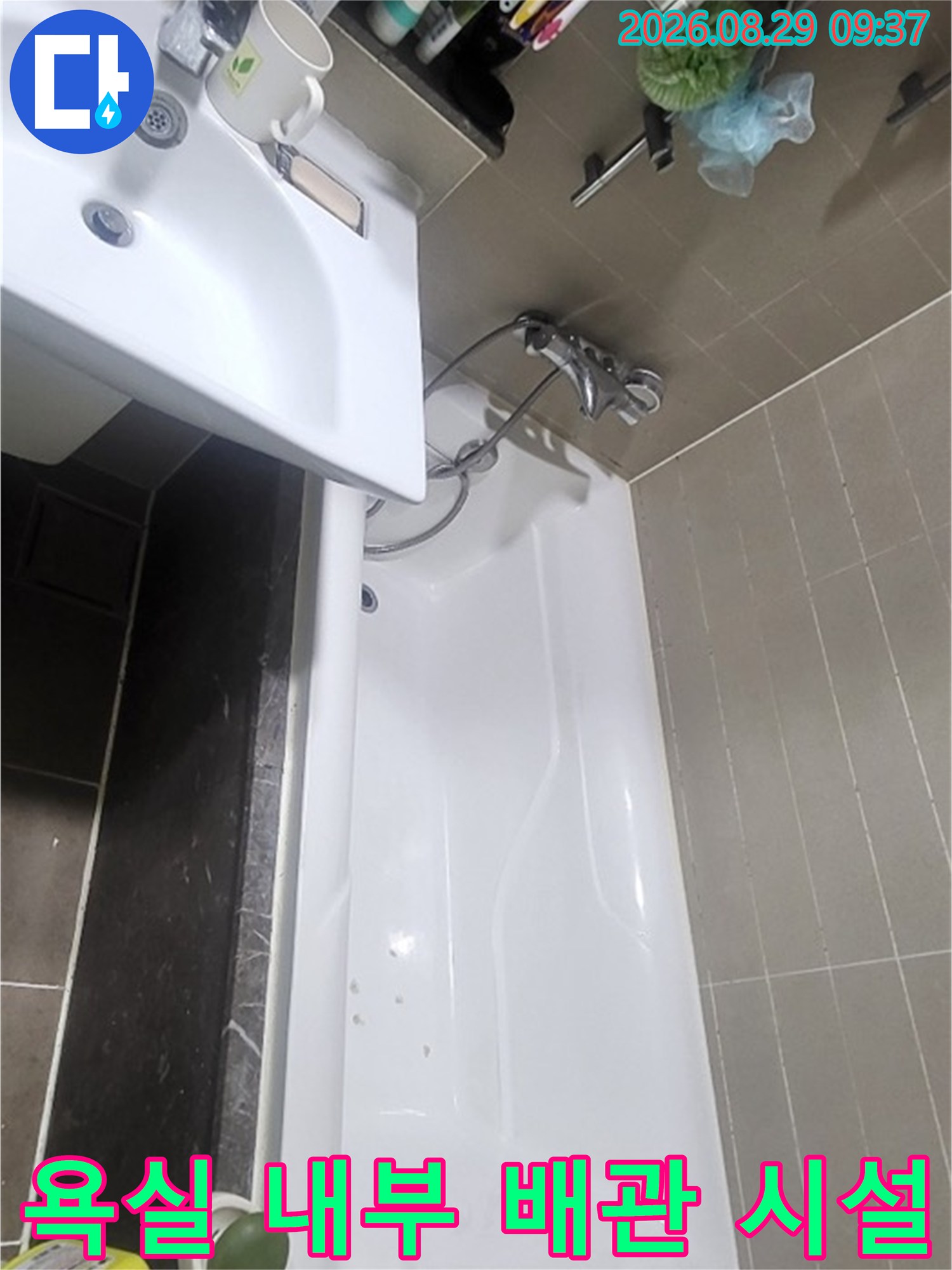 세면대 수전과 벽면 선반에 정리된 용품들-누수 점검 중인 욕실