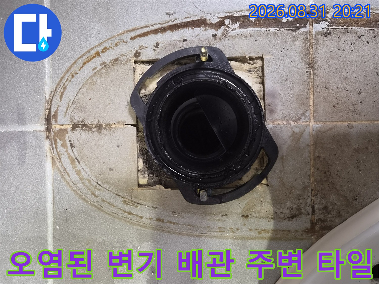 변기 배관 주위의 젖은 타일과 오염된 흔적을 상세히 촬영하였습니다.