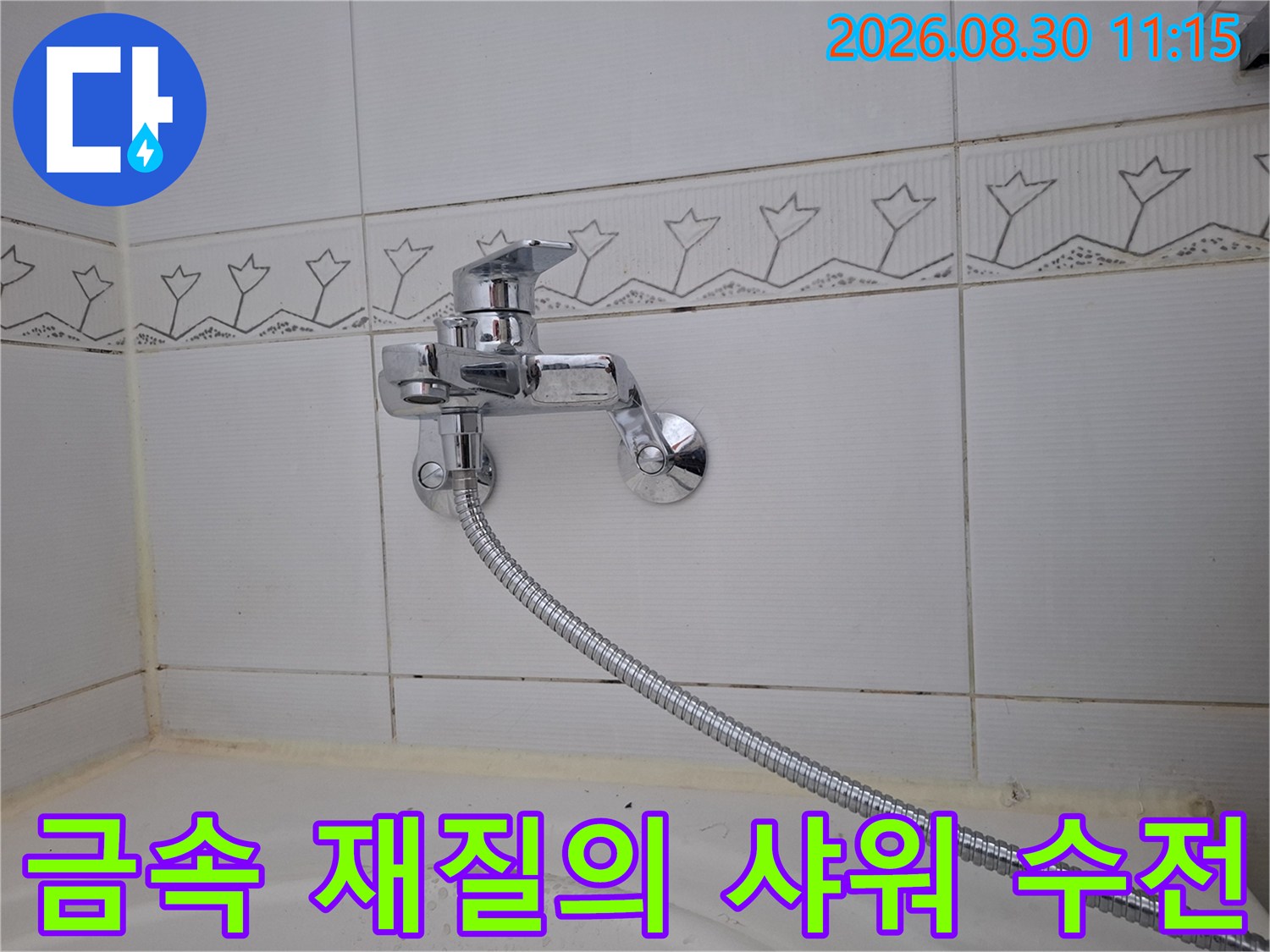 벽면 타일에 고정된 크롬 도금 수전과 샤워 호스 연결 모습입니다.