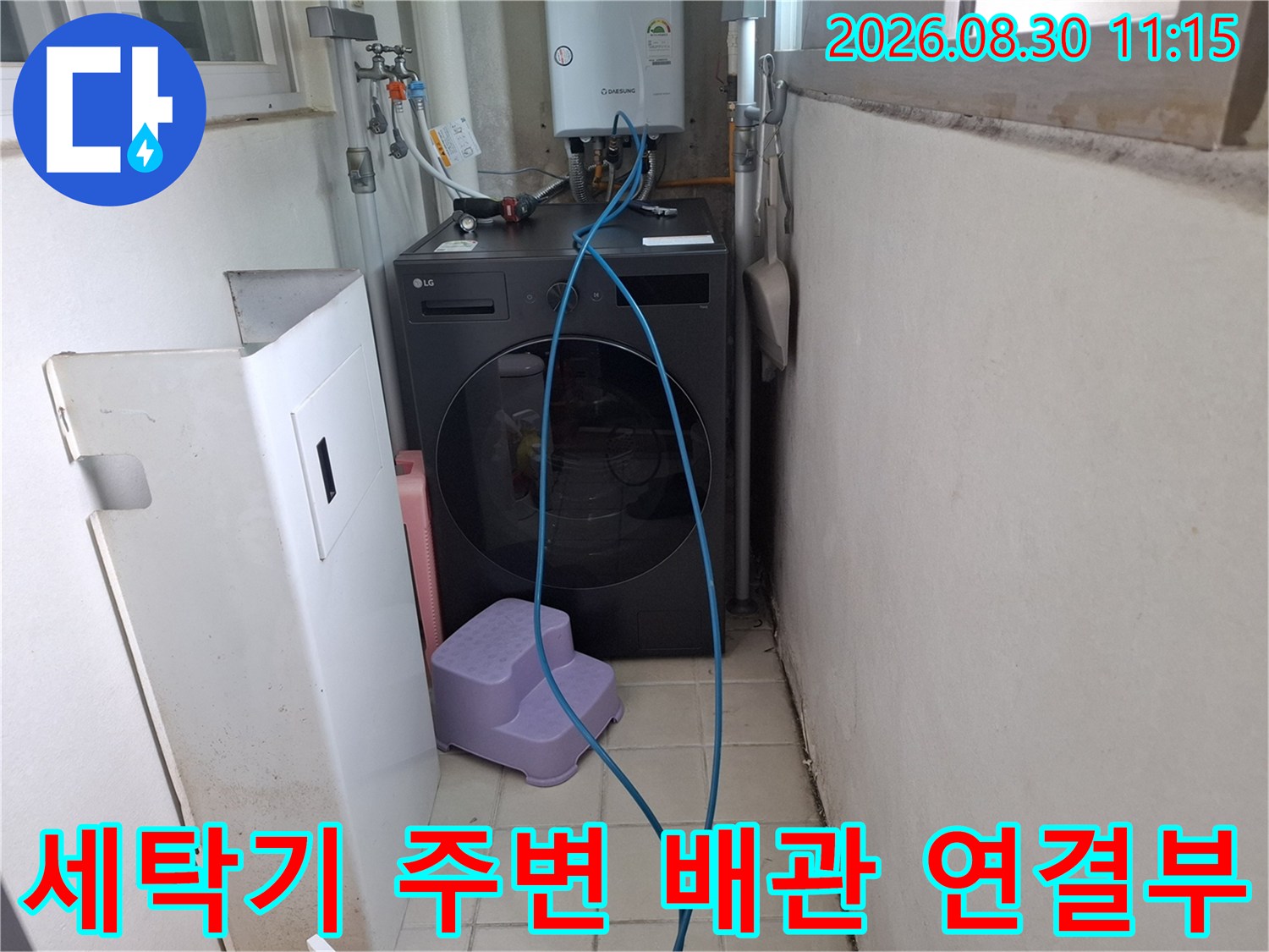 세탁기와 보일러 배관이 복합적으로 연결된 다용도실 내부 모습
