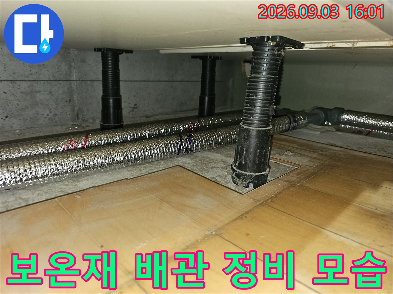 금속 재질의 보온재로 덮인 긴 배관과 이를 지탱하는 검은색 수직 구조물