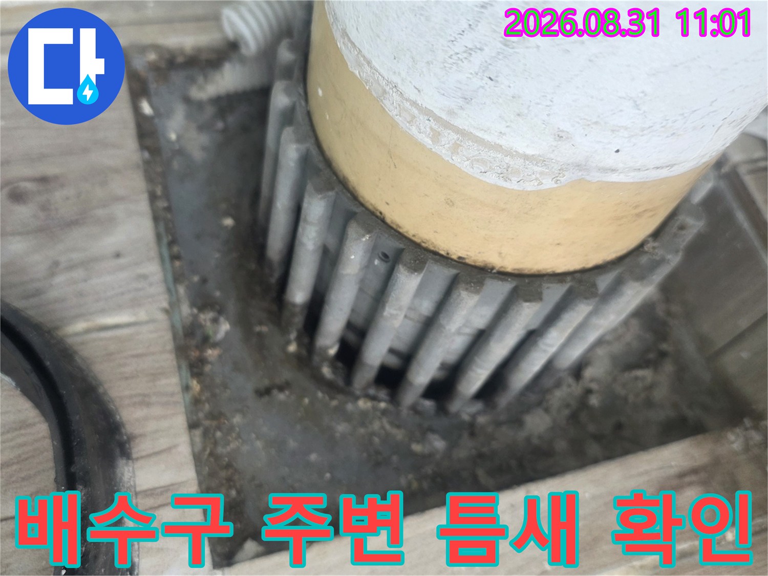 세탁실 배수관 주변의 벌어진 틈새와 노후된 마감 상태를 보여주는 사진입니다.