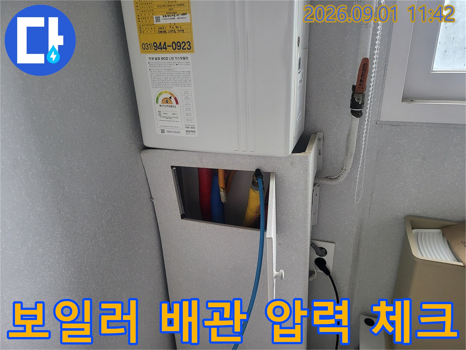 보일러 하부 배관 뭉치와 연결된 파란색 테스트 호스 모습