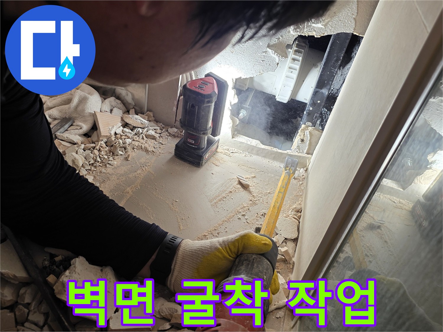 공구를 사용하여 벽면을 제거하고 내부 배관을 드러낸 현장