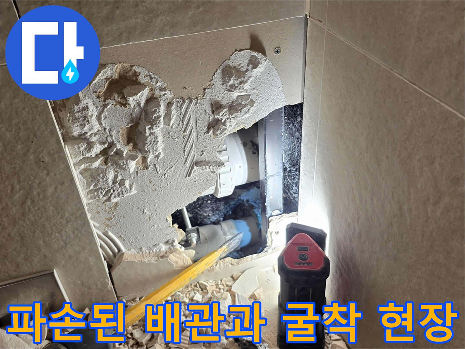 벽면 타일 제거 후 나타난 파손된 배관과 작업 잔해