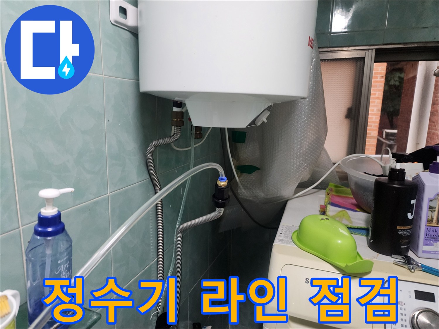 정수기 호스와 연결된 벽면 수도 배관의 상태를 확인하고 있습니다.