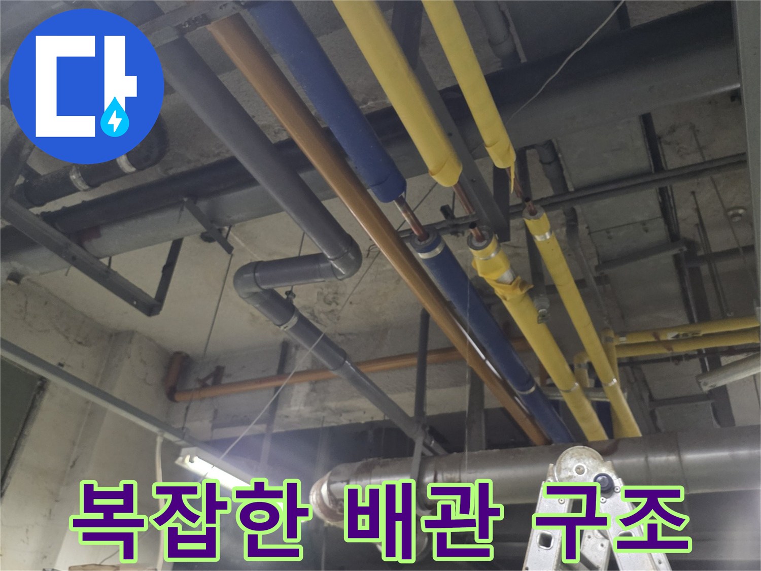 기계실 천장에 설치된 노란색과 파란색 보온 배관 라인