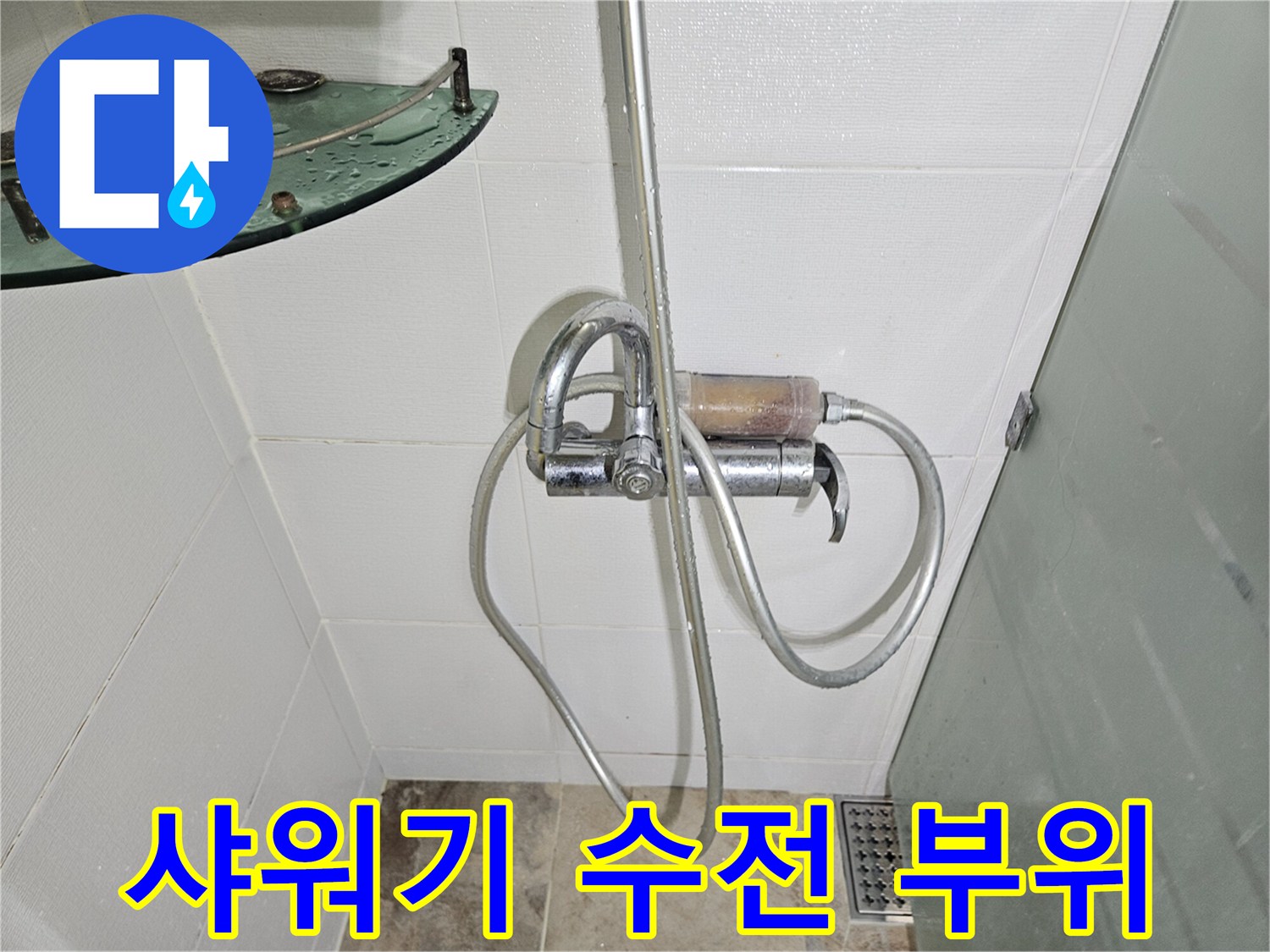 벽면에 설치된 샤워기 수전과 연결 호스의 근접 촬영 사진