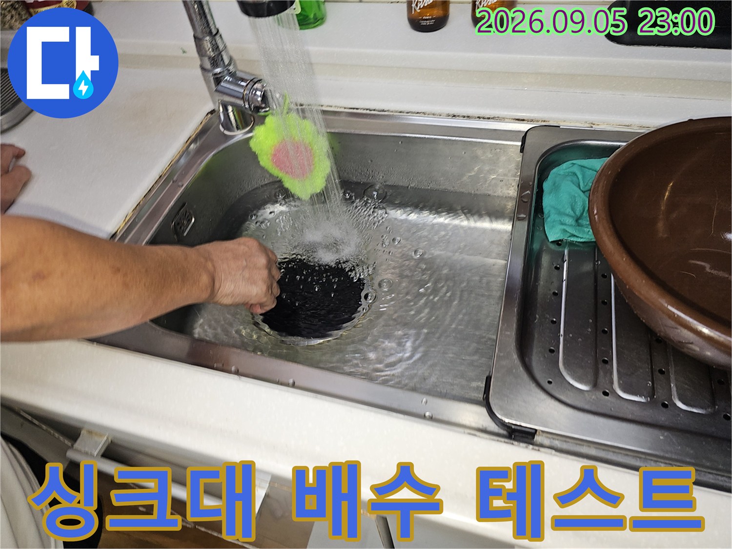 수돗물을 틀어 싱크대 배수구의 물 흐름을 관찰하는 작업 사진