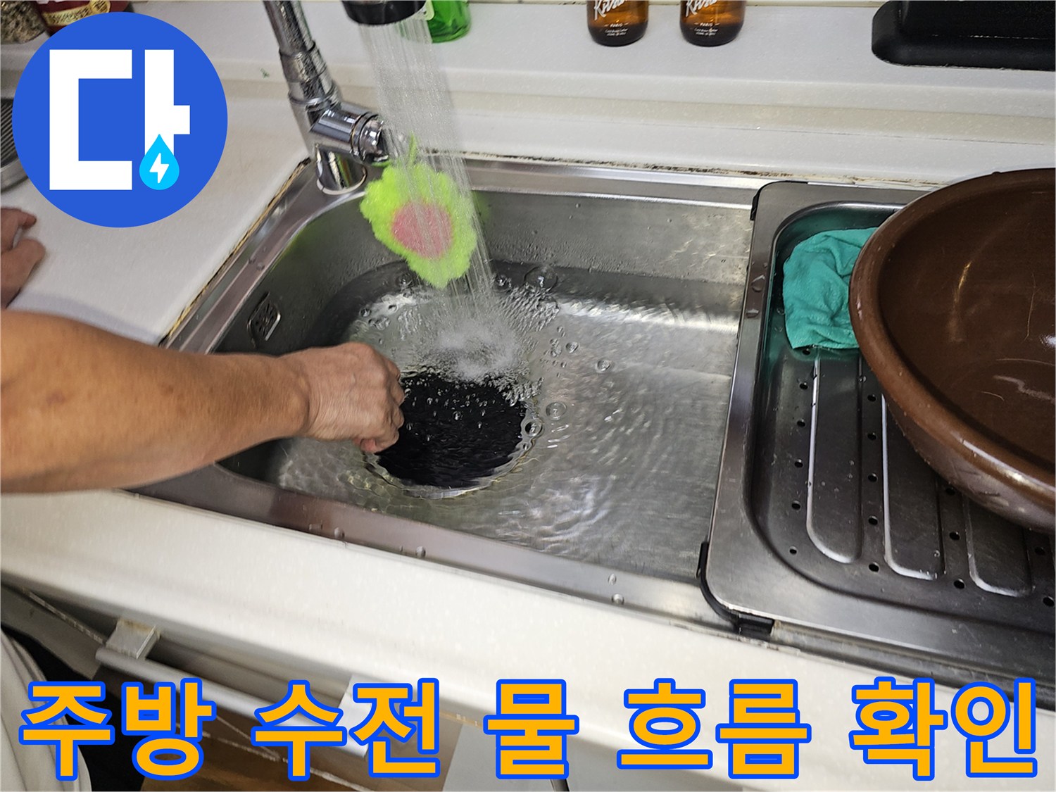 싱크대 수전에서 나오는 물줄기가 배수구를 향해 떨어지는 모습입니다.