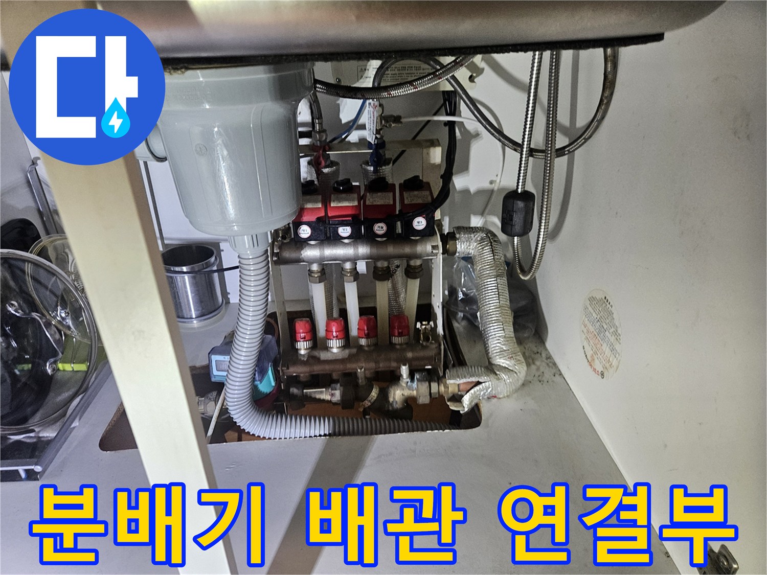 보일러 분배기와 싱크대 배수구가 함께 보이는 배관 구조입니다.