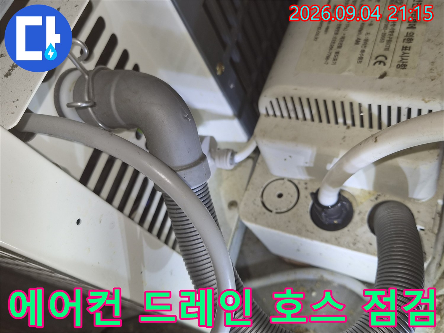 굵은-주름관 형태의 배수 호스와 장비 연결 부위 상세