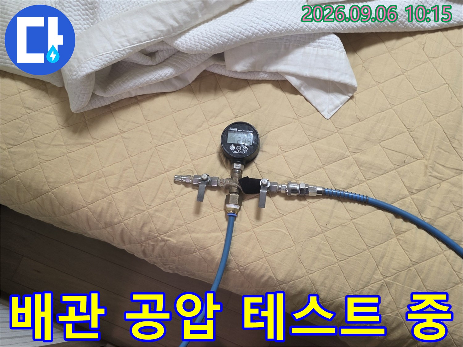 파란색 호스와 압력계가 연결된 배관 공압 테스트 장면