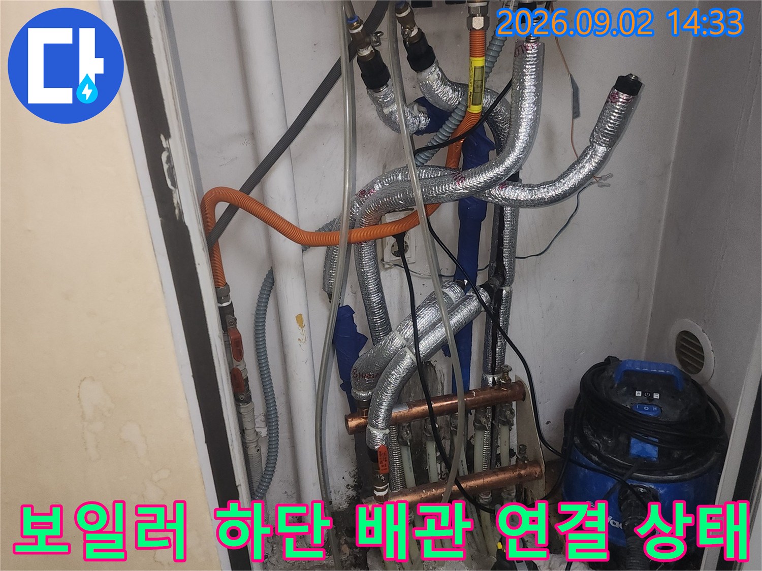 보일러 본체 아래쪽의 다양한 배관 분기점과 연결 부속들의 근접 촬영