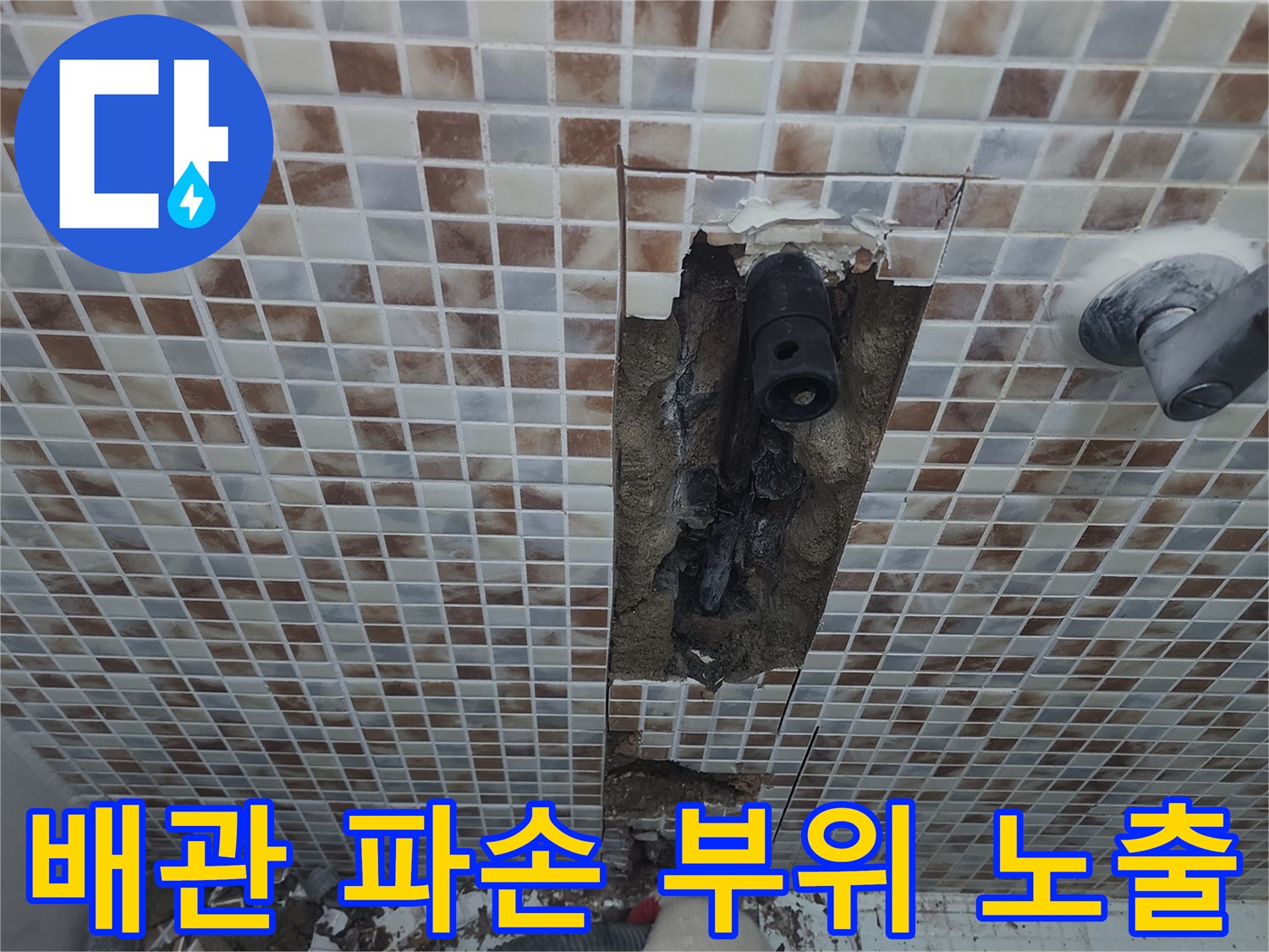 욕실 타일 내부에서 발견된 손상된 수도 배관의 모습
