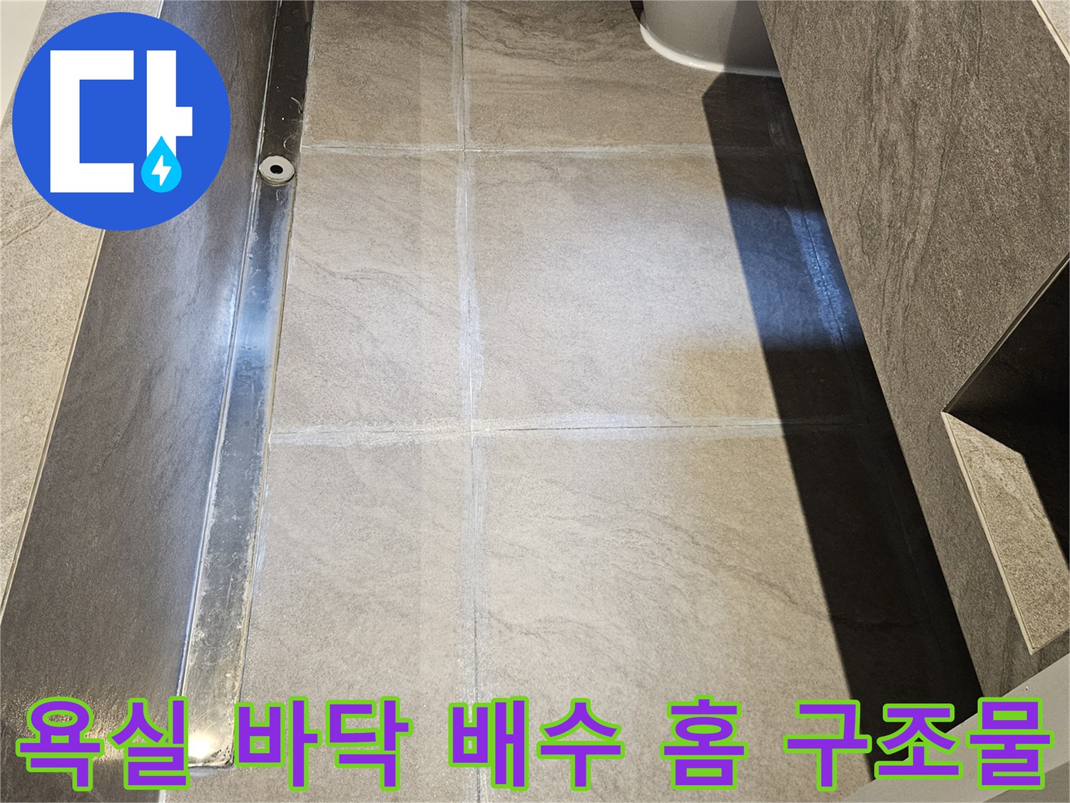 대리석 타일과 일체화된 욕실 배수 트렌치의 근접 촬영 사진입니다.