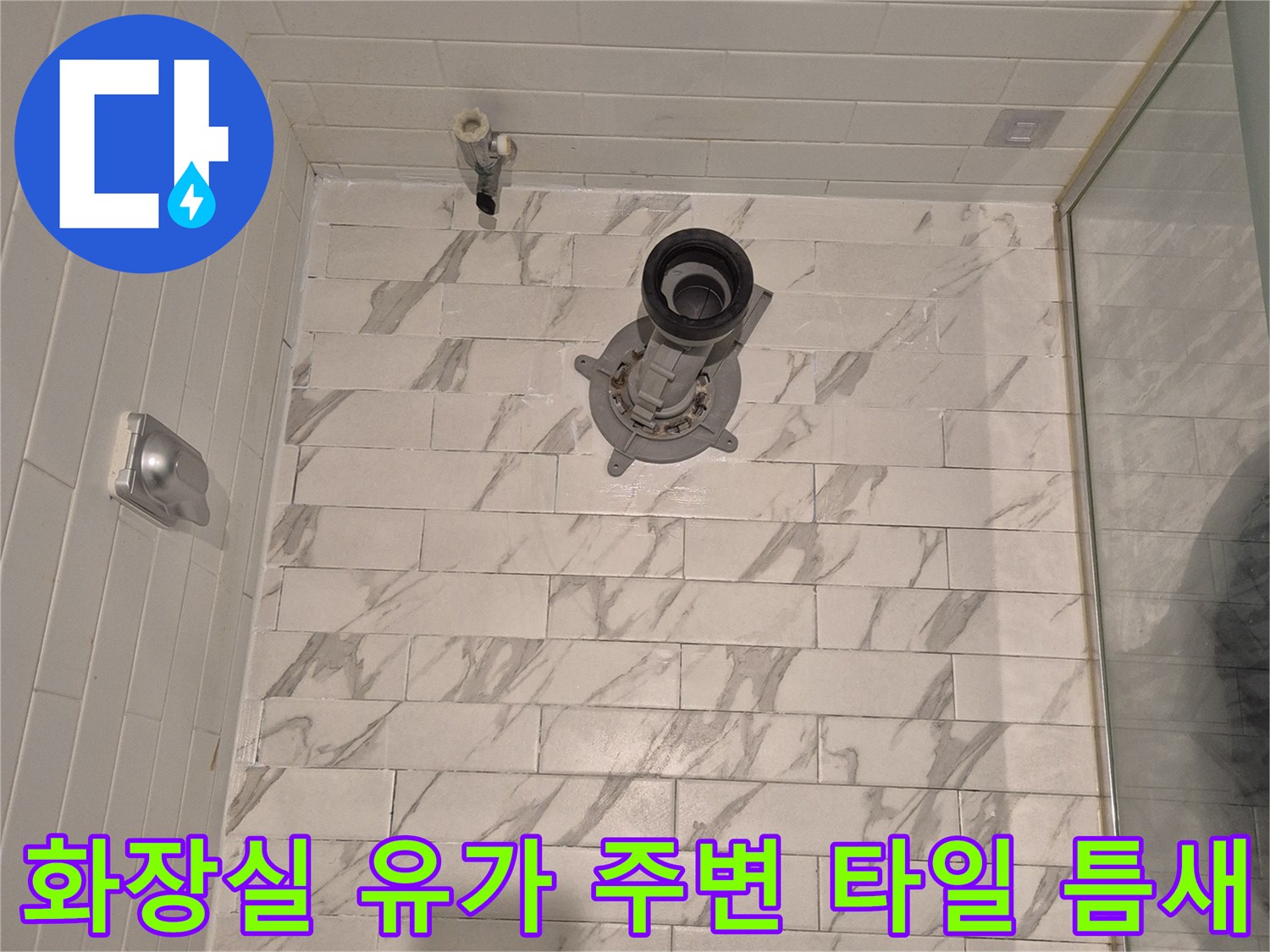 대리석 문양 타일과 금속제 배수구 입구 사진