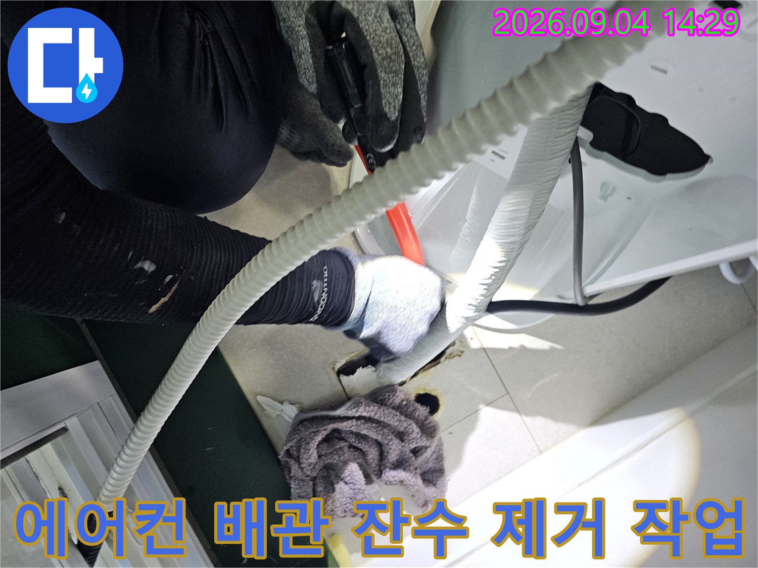 에어키 배관 내부의 물을 제거하기 위해 흡입 장비를 사용하는 모습입니다.