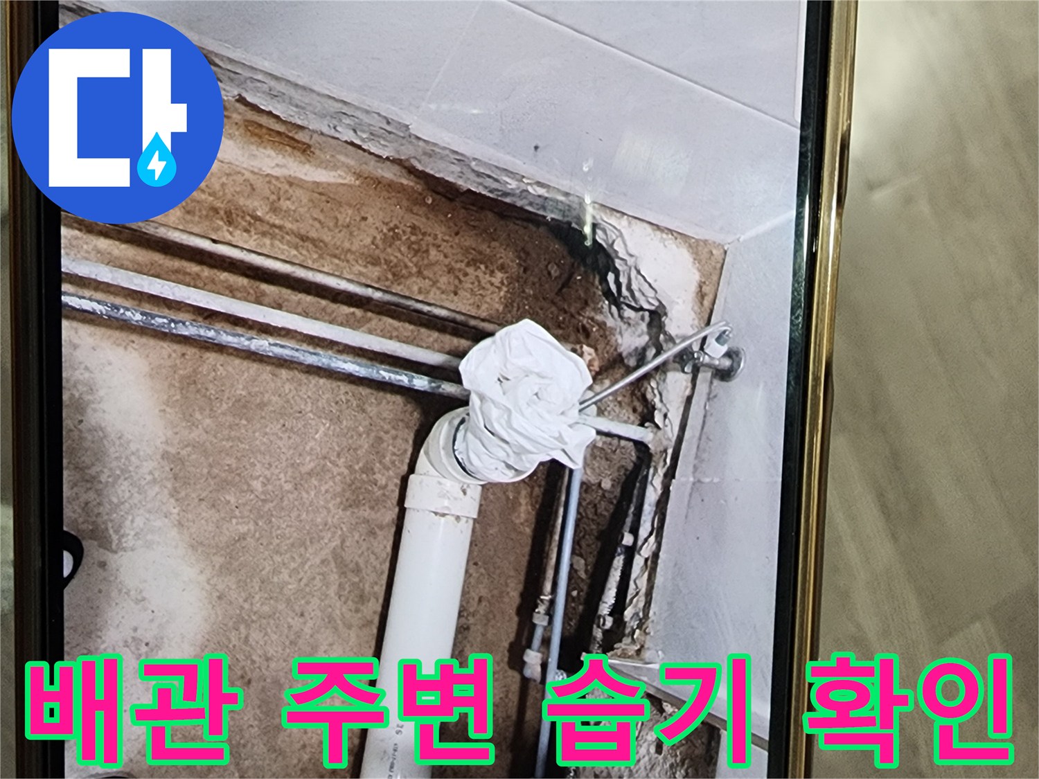 화장실 배관 주변의 젖은 바닥과 노출된 하수관 상태를 보여주는 사진