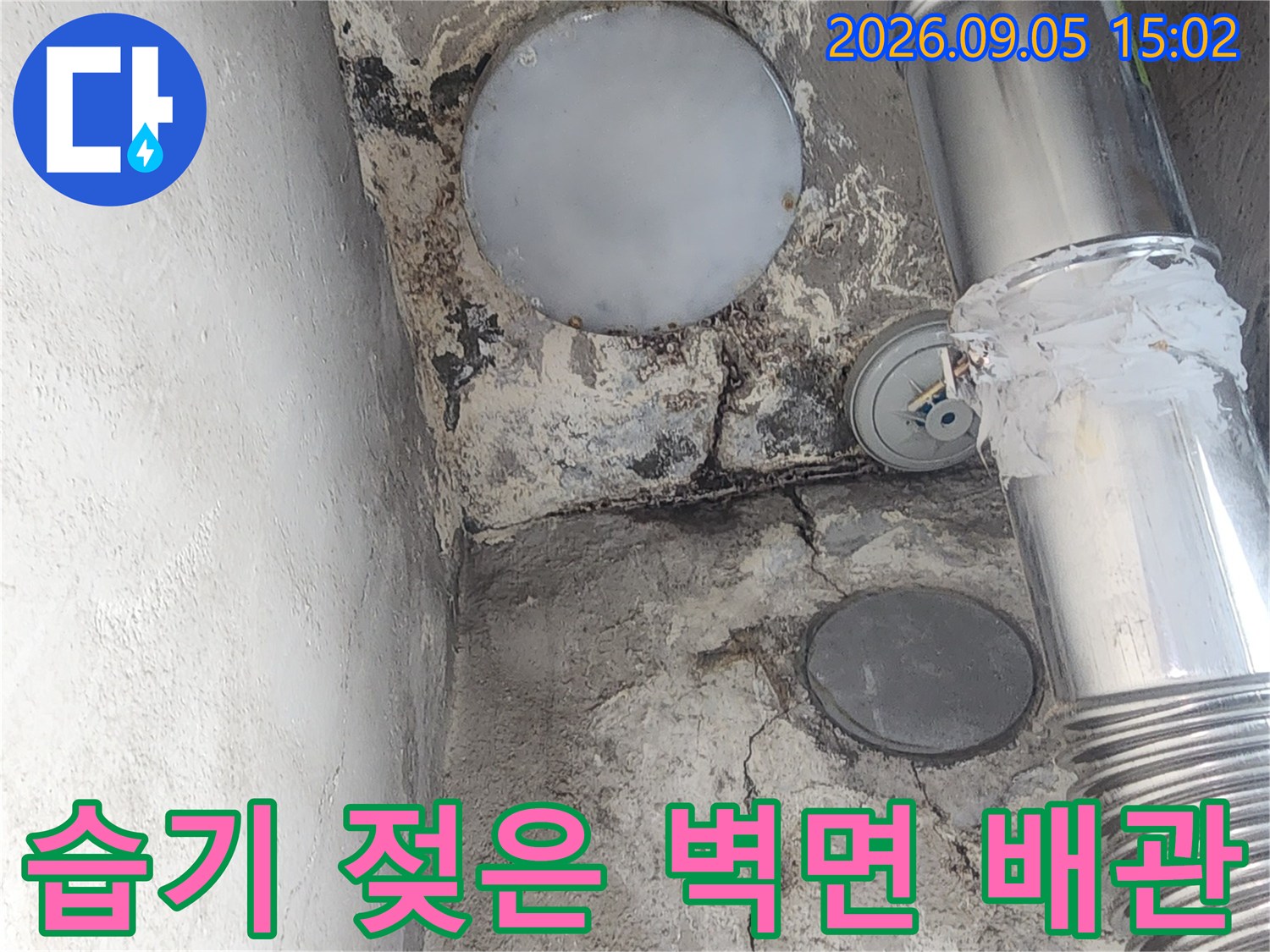 물기로 인해 변색된 벽면과 은색 보온재 마감된 배관