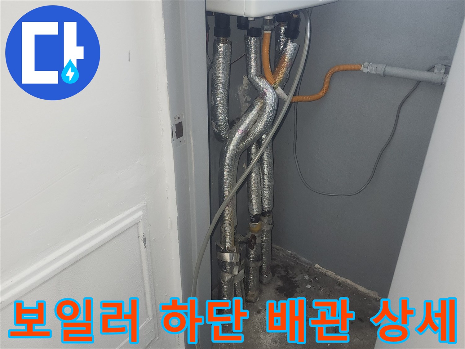 보일러 본체 밑으로 뻗어 나가는 금속 소재의 급수 배관