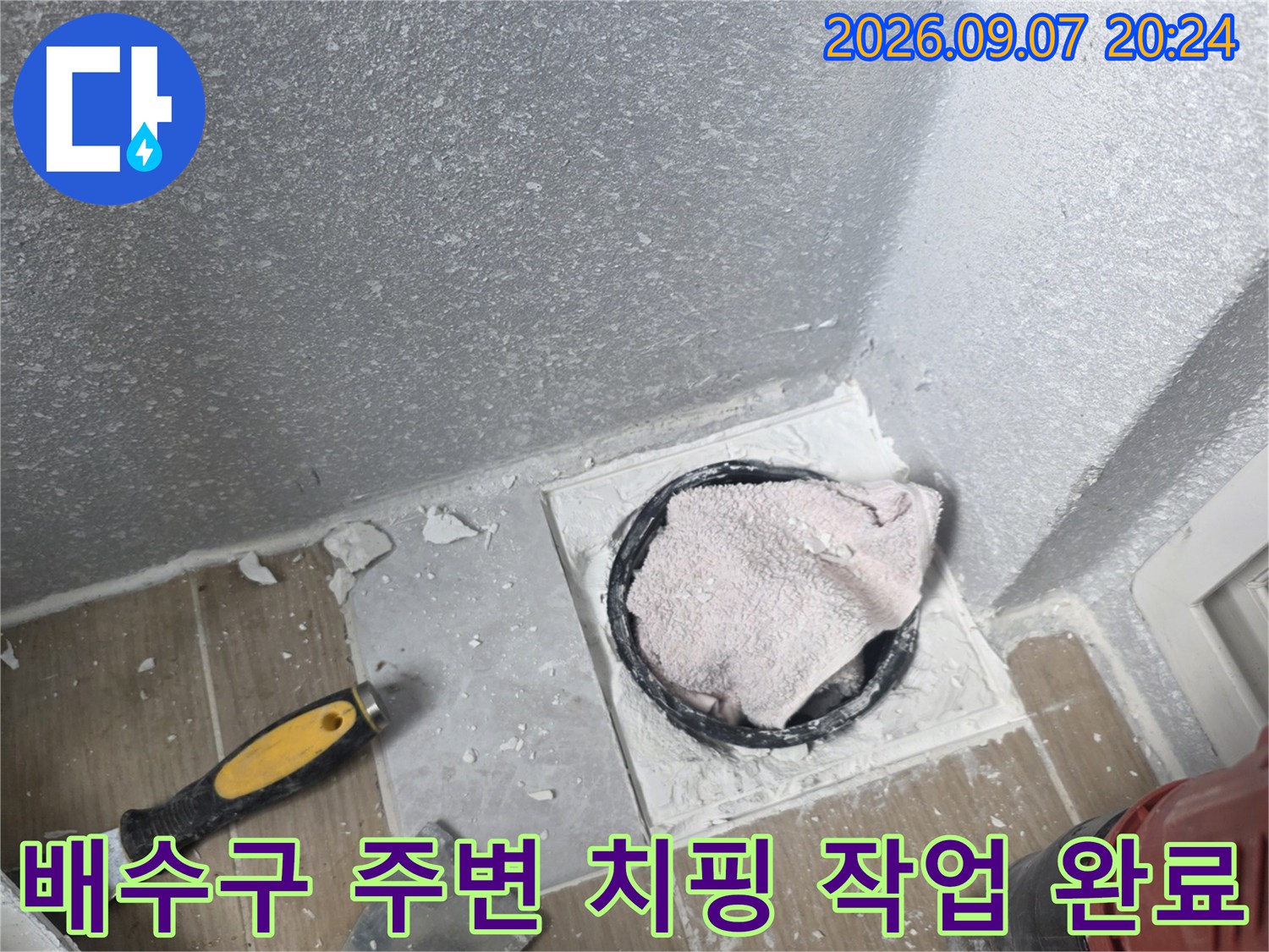 배수구 주변 타일을 제거하여 배관 연결 부위를 노출시킨 상태