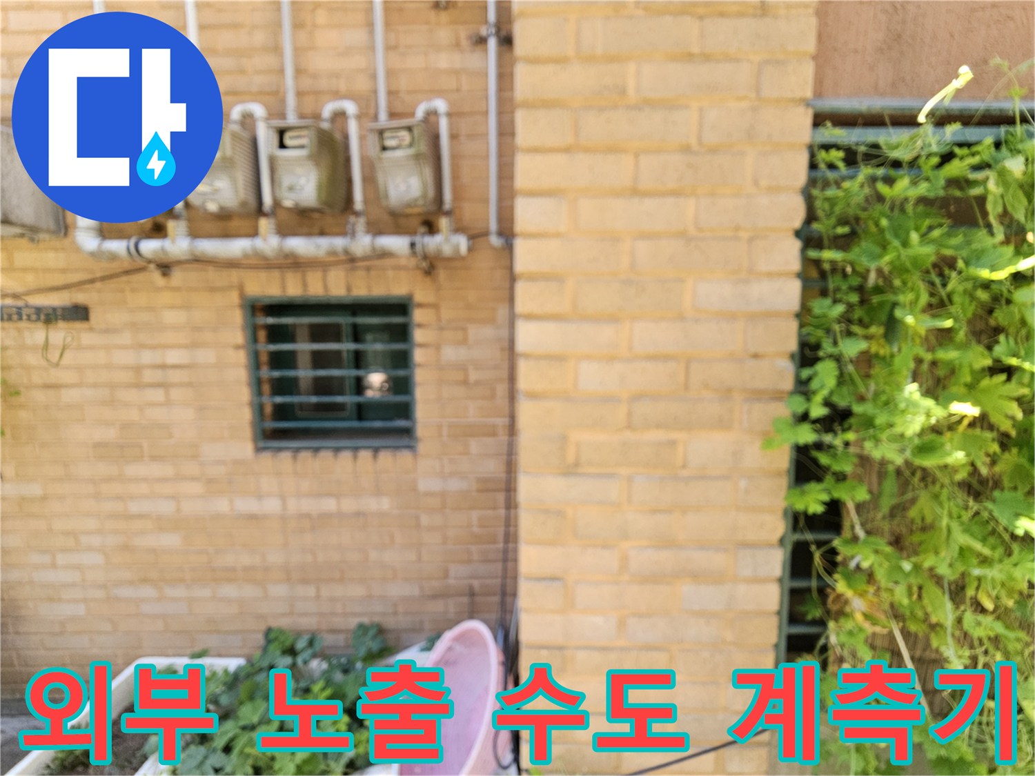 건물 외벽에 설치된 4개의 수도 계량기와 연결된 흰색 배관들