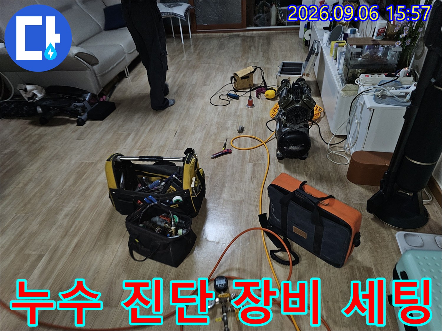누수 탐지를 위해 거실 바닥에 배치된 공압 테스트기와 각종 전문 장비들