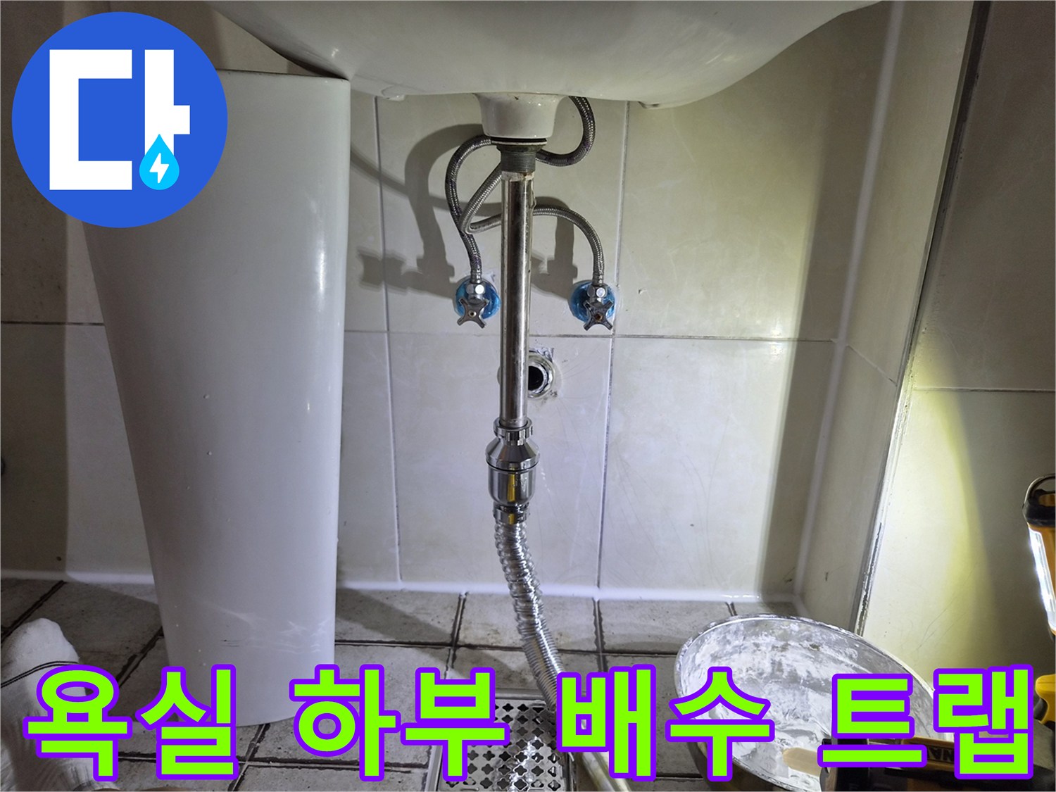 세면대 아래 은색 배수 호스와 벽면 급수 밸브 상세 사진