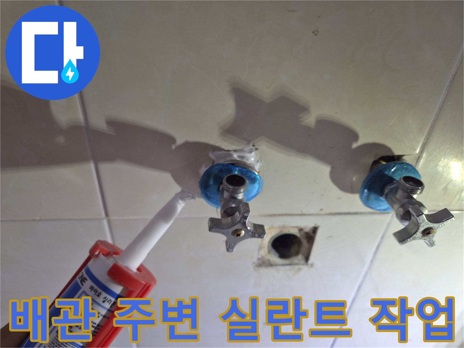 화장실 벽면 배관 틈새에-방수용 실란트를 도포하는 모습