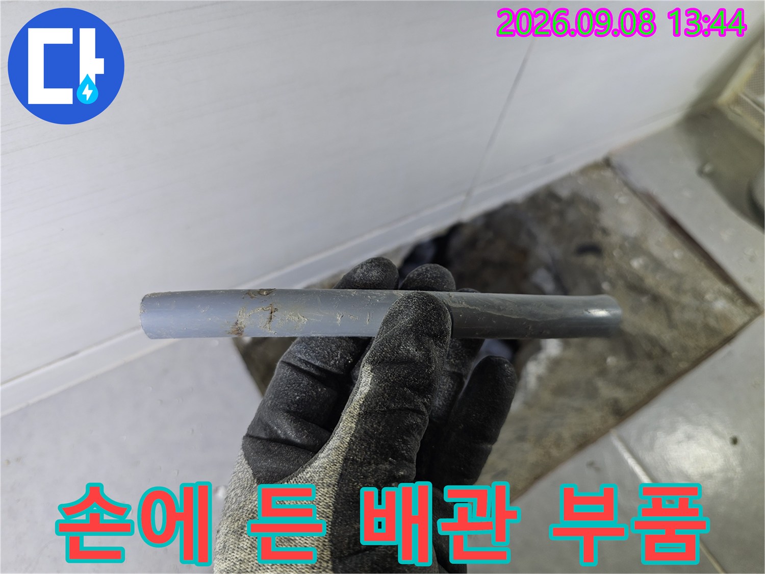 작업자가 손에 쥐고 있는 문제가 발생한 회색 배관 부위