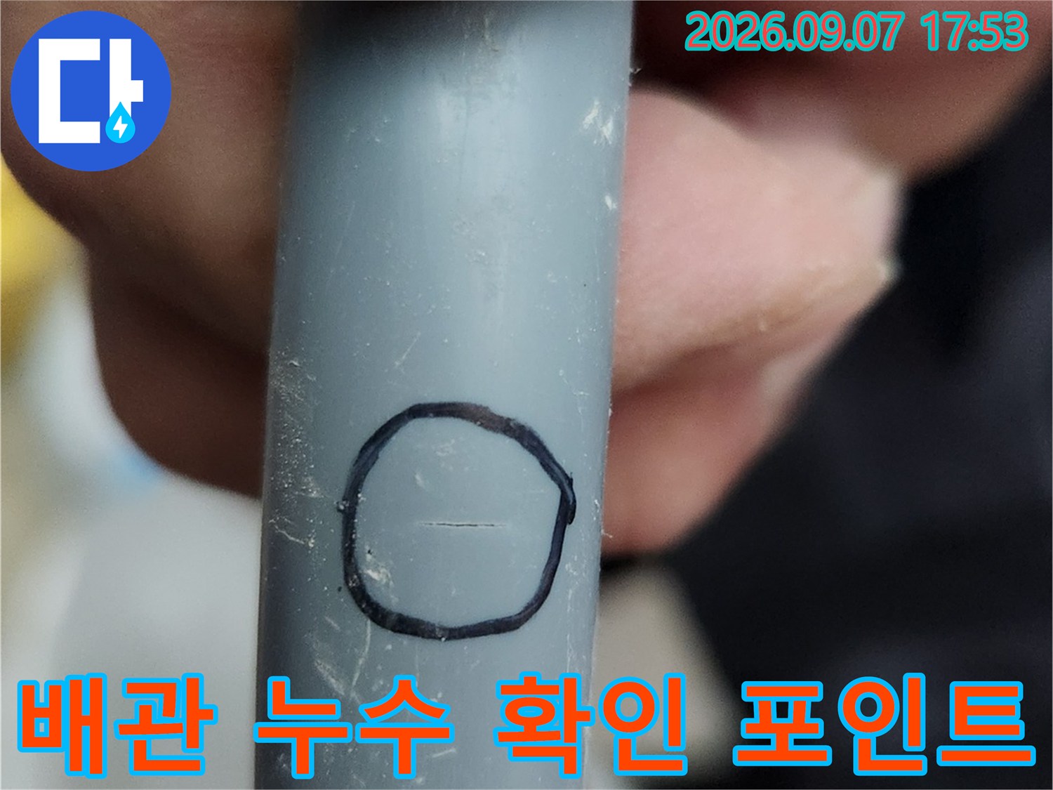 검은색 원으로 강조된-회색 배관의 파손 부위 상세 사진